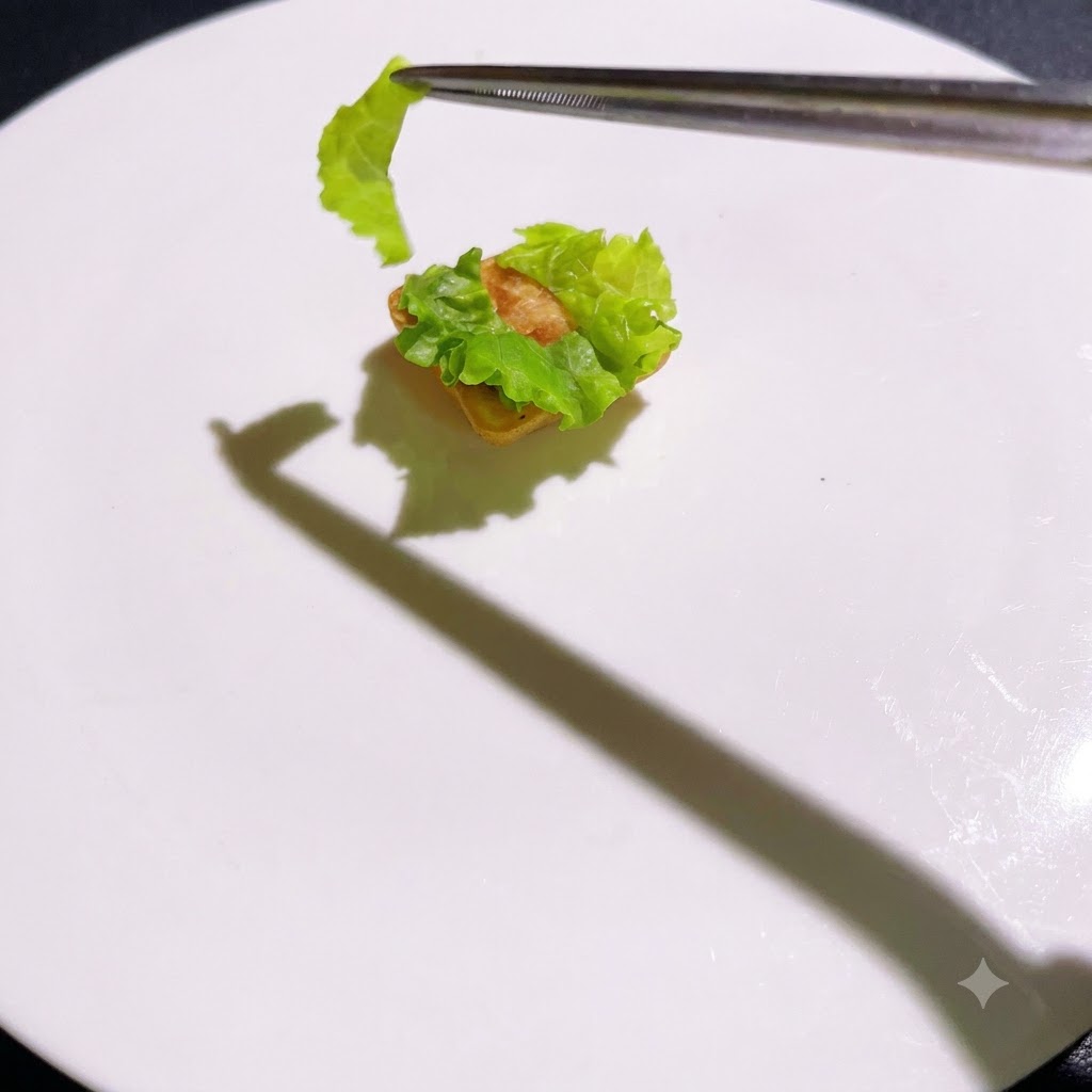 Cooked layers being stacked sequentially onto the lettuce base with tweezers.