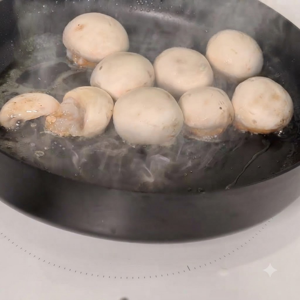 Shrimp-stuffed mushroom caps cooking in a hot skillet.