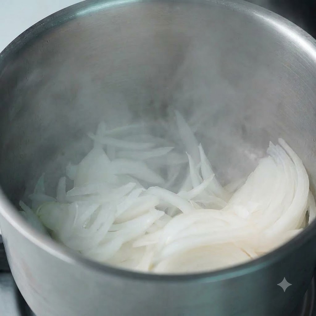Freshly sliced onions being dropped into a warm pot with rising steam.