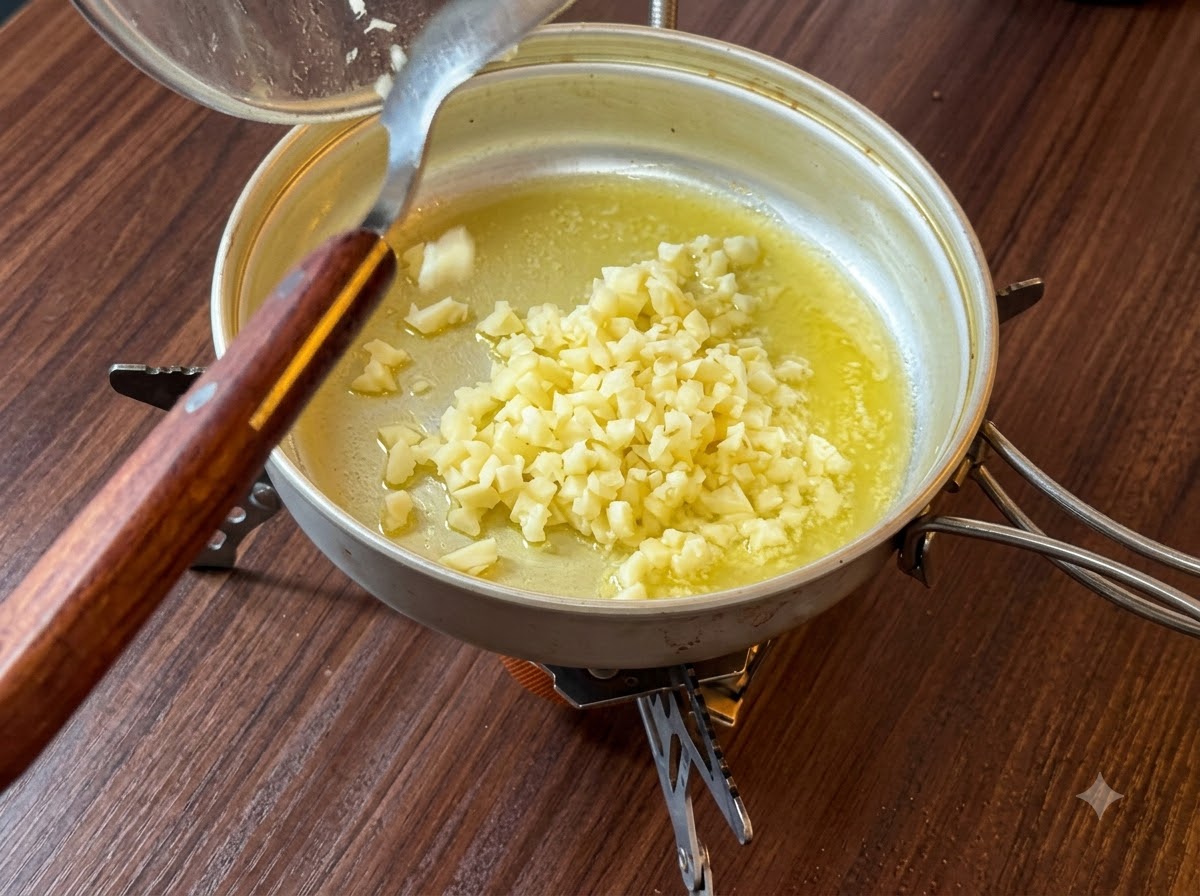 Finely chopped garlic being tipped from a container into melted butter in a pan.