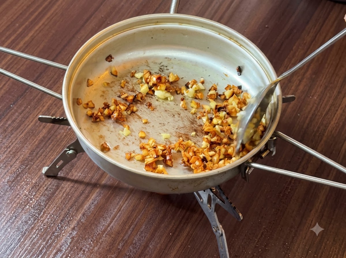 Minced garlic being tossed and browned in butter inside a frying pan.