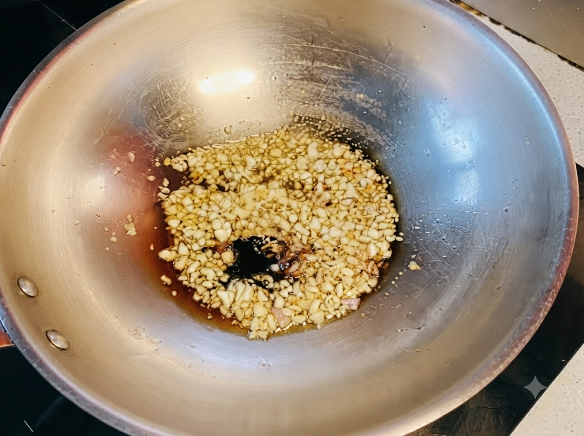 Dark and light soy sauces combined with honey bubbling over sautéed garlic in the wok.
