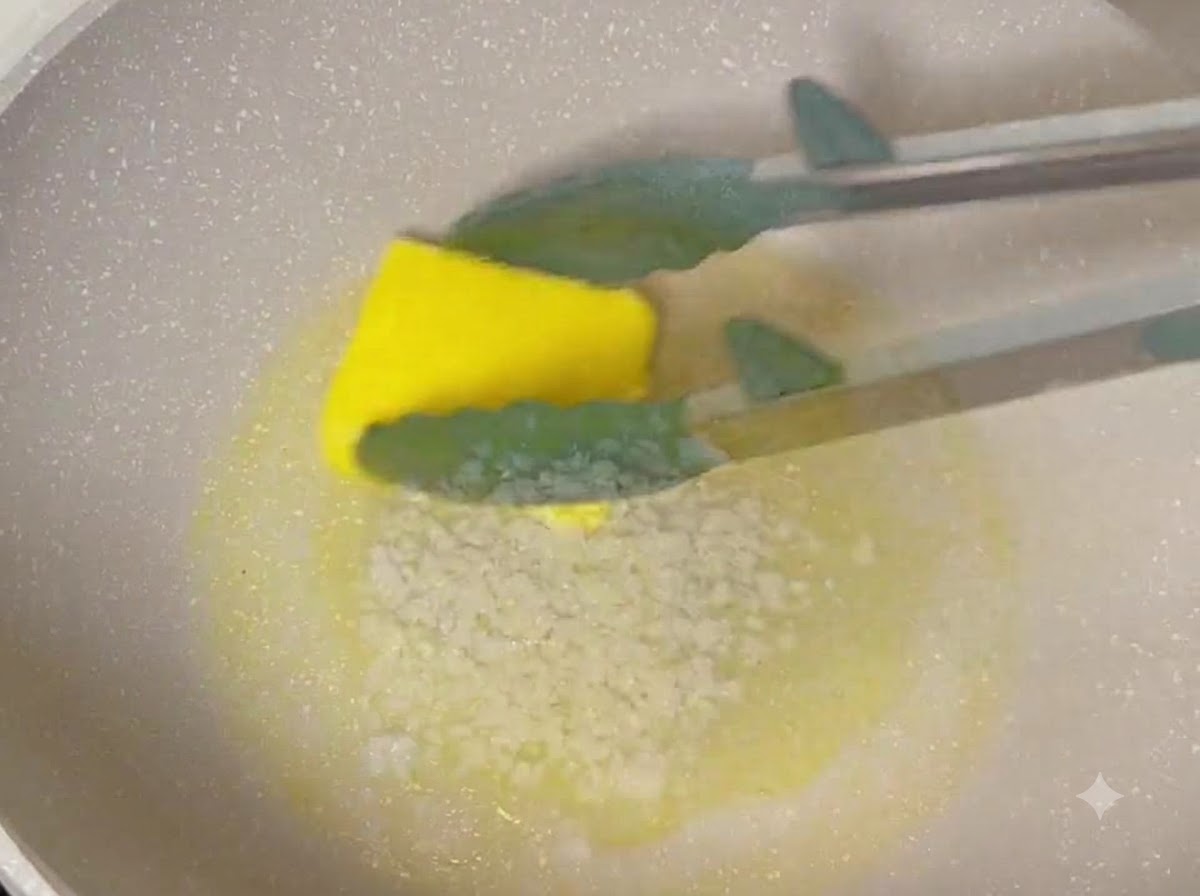 Minced garlic, soy sauce, oyster sauce, and honey being stirred into melted butter in a cooking pan.