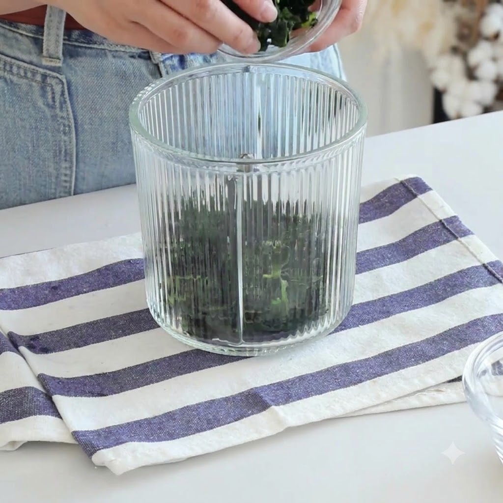 Ingredients being added into a ribbed glass food processor container.